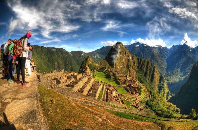 HDR image of tourists observing the wonder of Machu Picchu the lost city of the Inca near Cusco Peru